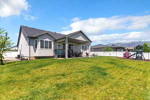 Back of property with stucco siding, a fenced backyard, a patio, and a playground