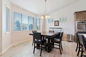 Dining area featuring a chandelier, plenty of natural light, and light wood-style flooring