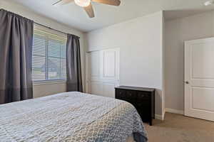 Bedroom featuring carpet floors, a textured ceiling, ceiling fan, and a closet