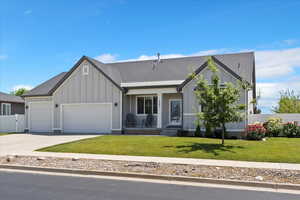 Modern farmhouse with board and batten siding, an attached garage, concrete driveway, and covered porch