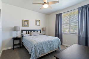 Carpeted bedroom featuring baseboards and ceiling fan