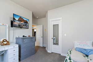 Bedroom featuring dark colored carpet and baseboards