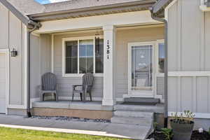 Property entrance with a porch and roof with shingles