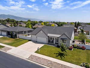 Ranch-style house with board and batten siding, a residential view, concrete driveway, a garage, and a mountain view