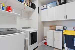 Laundry area featuring washer and clothes dryer and cabinet space