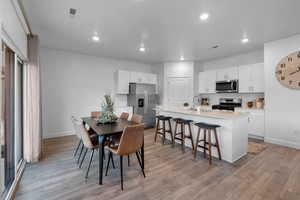 Dining space with light wood-type flooring and recessed lighting