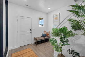Entrance foyer with light wood-style flooring and recessed lighting