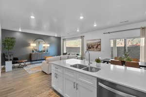 Kitchen with dishwasher, recessed lighting, light wood-style flooring, light countertops, and white cabinetry