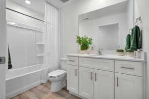 Full bath with vanity, wood finished floors, and shower / bath combo