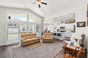 Family room featuring access to covered patio, dark wood-style floors, healthy amount of natural light, a chandelier,recessed lighting and plantation shutters