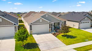 View of front of property featuring board and batten siding, stone siding, a residential view, and a front yard