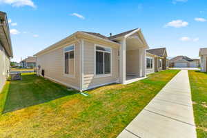 View of property exterior featuring a lawn and a central AC unit