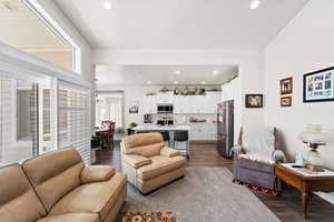 Family room area featuring dark wood-style flooring, recessed lighting, and a chandelier