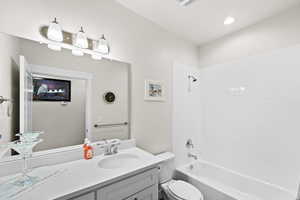 Full bath featuring vanity and washtub / shower combination