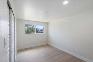 Unfurnished bedroom featuring a closet, light wood-style floors, and recessed lighting