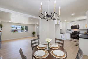 Dining room featuring light wood-type flooring, a chandelier, and recessed lighting
