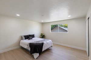 Bedroom with light wood-style floors and recessed lighting