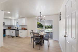 Dining room with a chandelier, healthy amount of natural light, light wood-style floors, and recessed lighting