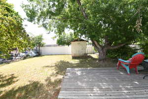 Wooden deck with a fenced backyard and a shed