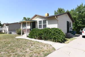 View of front of house with a chimney and a front lawn
