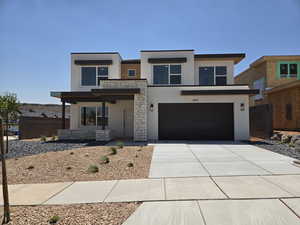 Contemporary house with stucco siding, an attached garage, concrete driveway, and stone siding