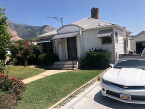 View of front facade with a front yard, a chimney, and a mountain view