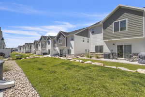 Rear view of house featuring a residential view, a lawn, and a patio area