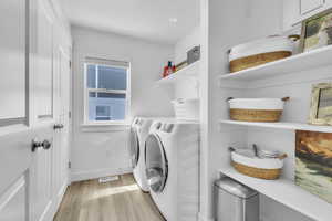Laundry area featuring washing machine and dryer and light wood finished floors