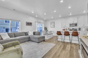 Living area with light wood-style floors and recessed lighting