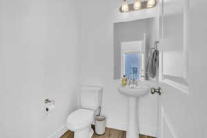 Bathroom with toilet and wood finished floors