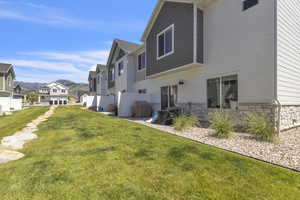 Rear view of property featuring stone siding, a residential view, and a mountain view