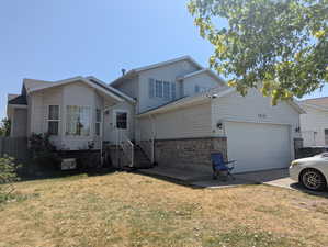 View of front of property with a garage, a front lawn, driveway, and brick siding