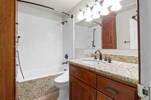 Bathroom featuring vanity, shower / tub combination, and tile patterned flooring