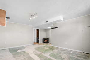 Unfurnished living room with a wood stove and unfinished concrete floors