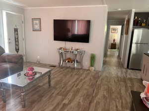 Living area featuring crown molding and wood finished floors