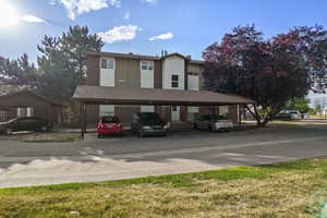 View of front of house with covered parking and a shingled roof