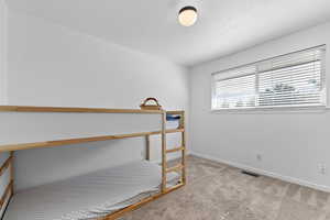 Bedroom featuring carpet and baseboards