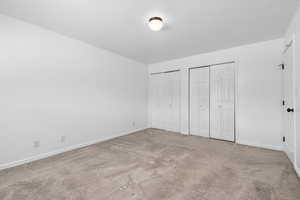 Bedroom with carpet flooring and multiple closets