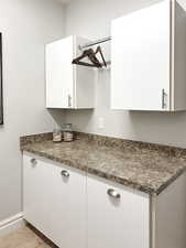 Kitchen with white cabinetry, dark countertops, and light tile patterned flooring