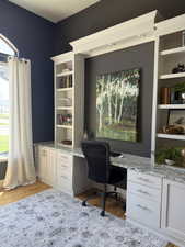 Office space with built in study area and light wood finished floors