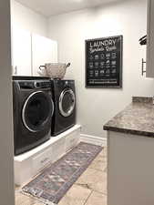 Washroom featuring cabinet space and separate washer and dryer