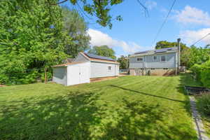 View of grassy yard featuring a storage shed