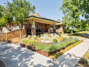 View of front facade featuring brick siding and roof mounted solar panels
