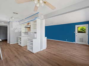 Unfurnished living room with wood finished floors and ceiling fan
