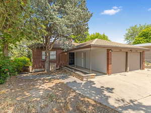 Single story home featuring brick siding, a garage, and concrete driveway