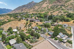 Aerial view of property and surrounding area with a mountain backdrop and nearby suburban area