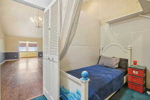 Bedroom featuring a chandelier and wood finished floors