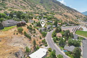 Aerial overview of property's location with a mountainous background and nearby suburban area