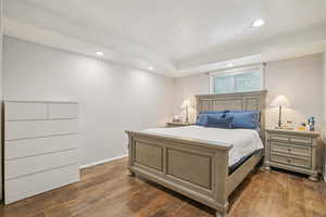 MIL - Bedroom featuring dark wood-style flooring and recessed lighting