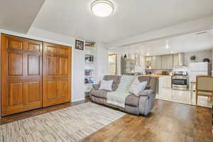 MIL - Living room with light wood-style floors and built in shelves
